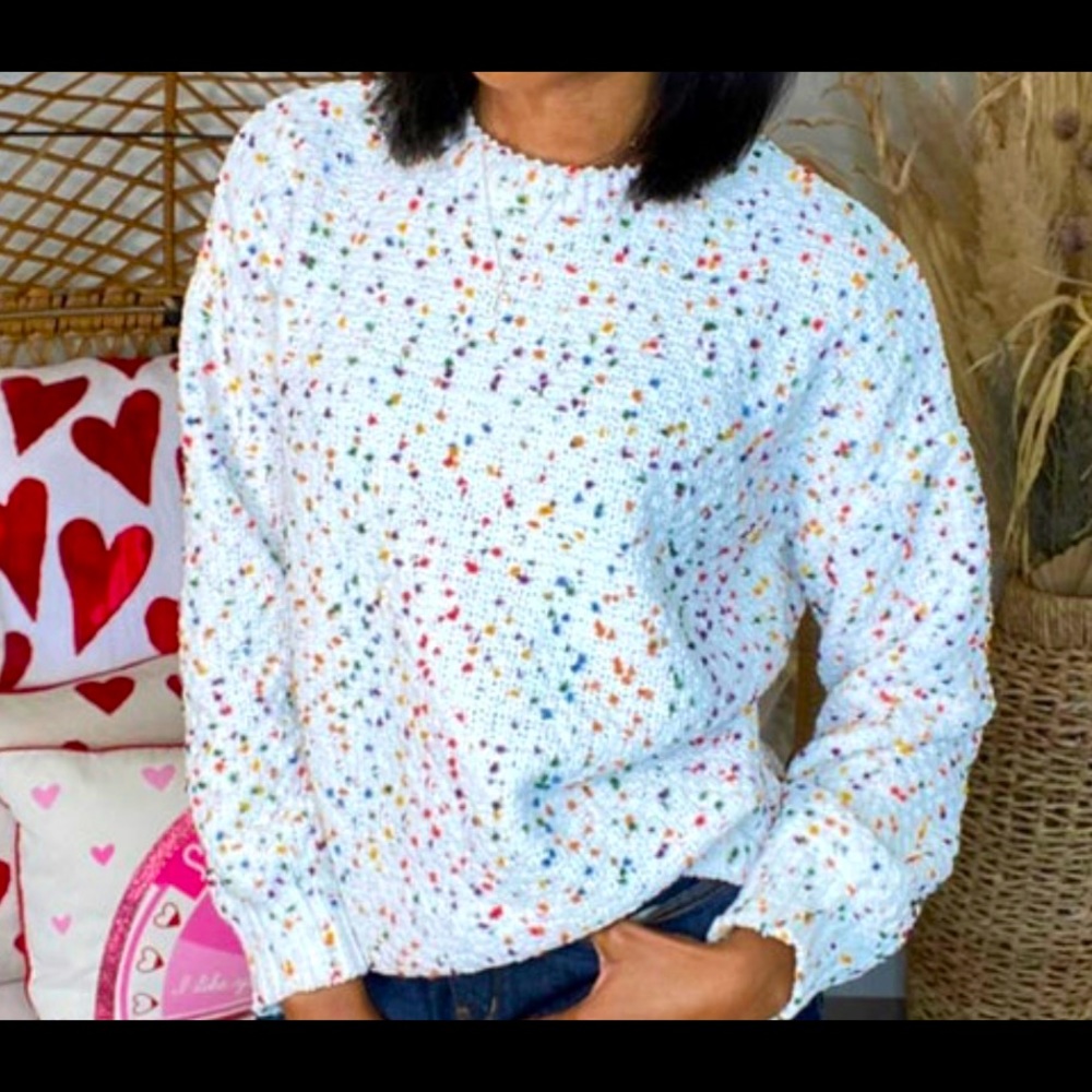Adorable cream sweater with confetti designs.